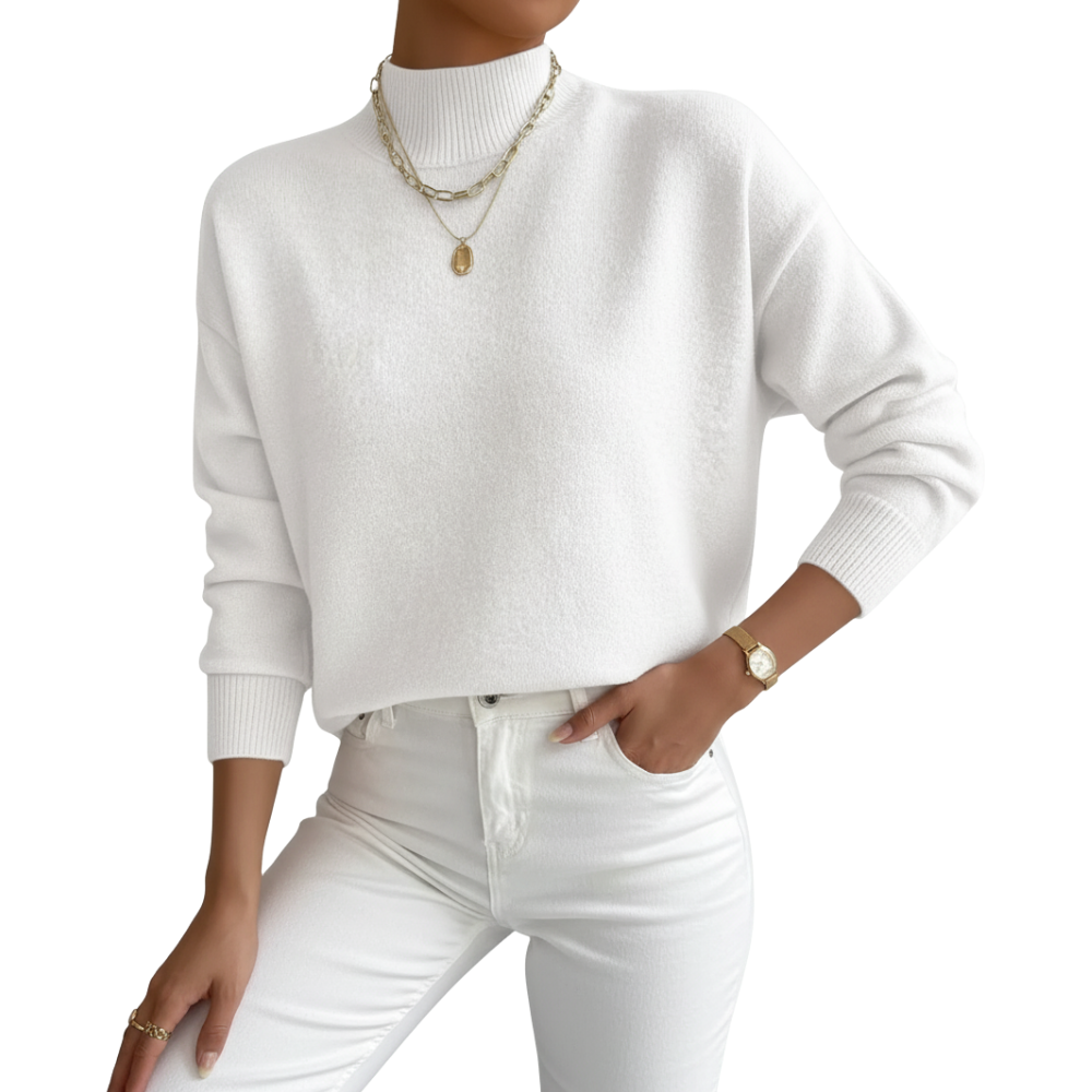 Person wearing a white sweater and white pants with gold jewelry on a white background